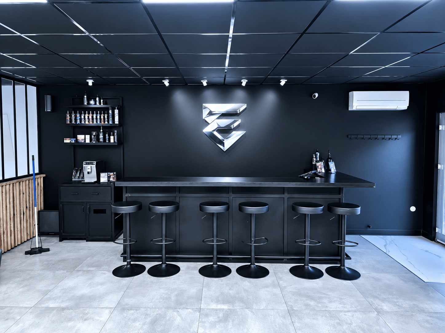 Le comptoir et l'espace bar du salon Everest Barbershop
